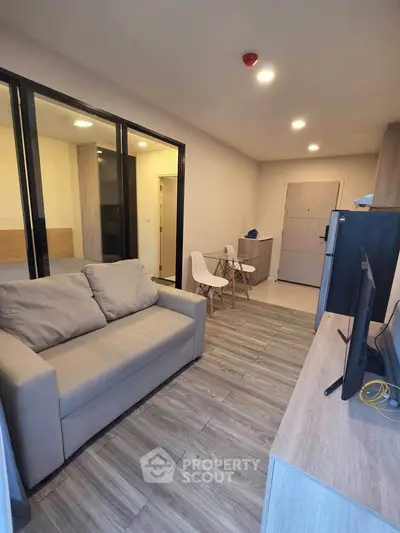 Modern living room with cozy sofa and sleek wooden flooring in a stylish apartment.