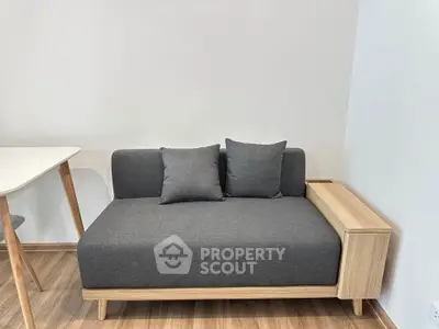 Modern minimalist living room with stylish gray sofa and wooden accents