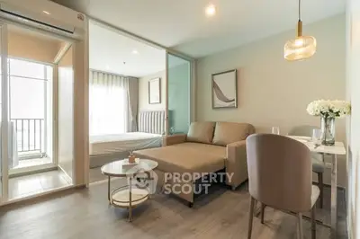 Modern open-plan living room with cozy sofa and dining area in a stylish apartment.