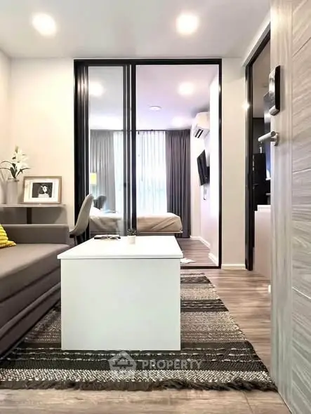 Modern living room with stylish decor and view into cozy bedroom