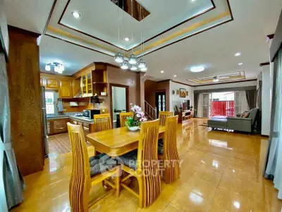 Spacious open-plan living and dining area with modern kitchen and elegant lighting.