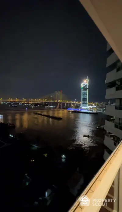 Stunning night view of riverfront cityscape from high-rise balcony