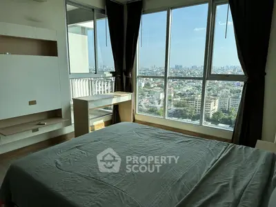 Spacious bedroom with large windows offering stunning city views, perfect for urban living.