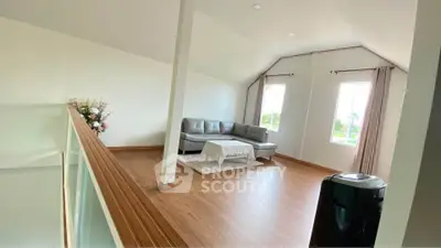 Spacious living room with modern sofa and large windows offering natural light