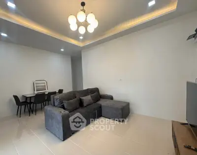 Modern living room with stylish gray sofa and elegant dining area