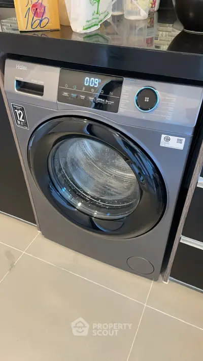Modern washing machine in sleek kitchen interior with contemporary design.