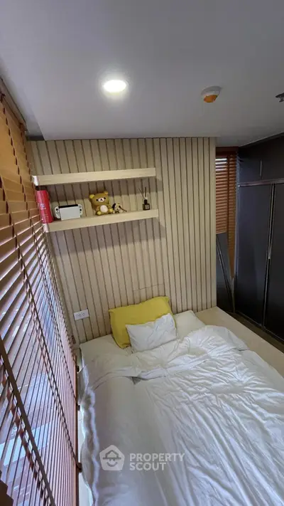 Cozy bedroom with modern decor and plush bedding, featuring a stylish wooden accent wall and ample natural light.