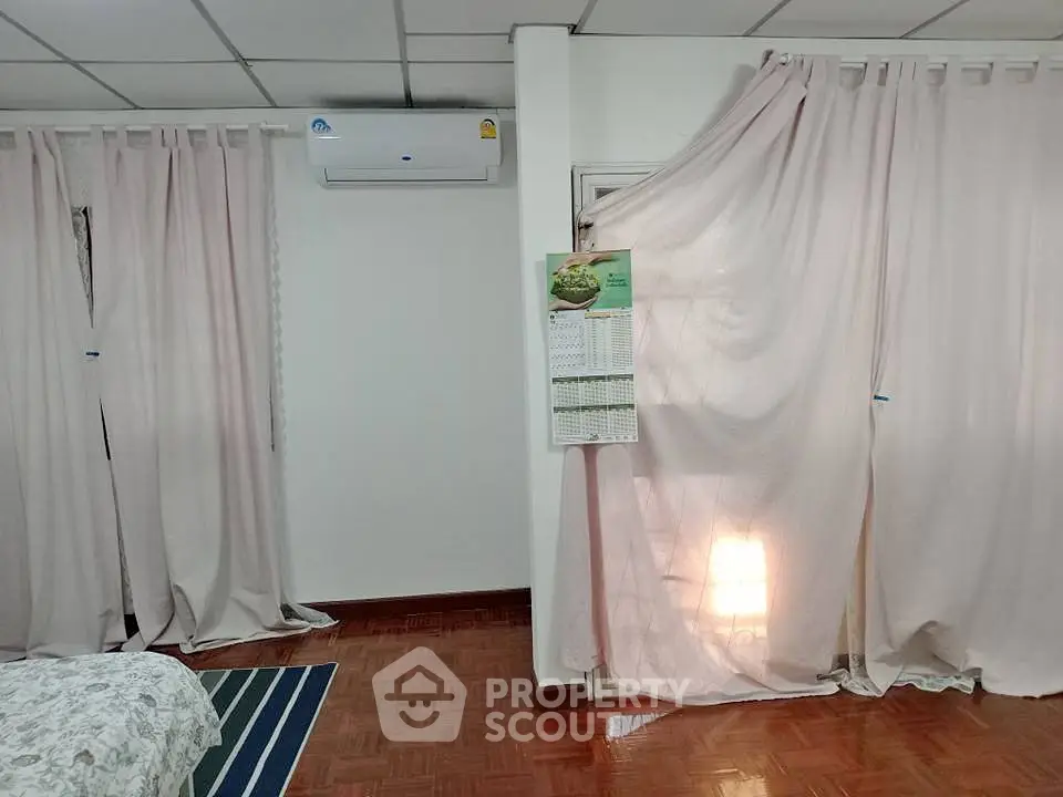 Cozy bedroom with air conditioning and soft curtains, perfect for relaxation.