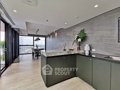 Modern kitchen with open layout and stunning city view, featuring sleek cabinetry and elegant decor.