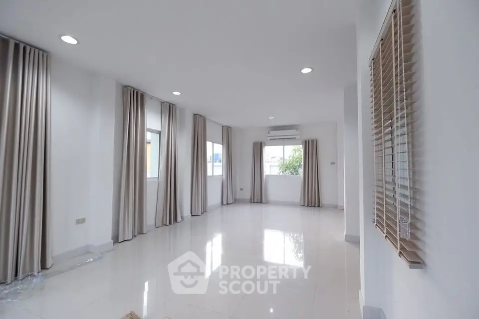 Spacious empty living room with large windows and elegant curtains, perfect for customization.