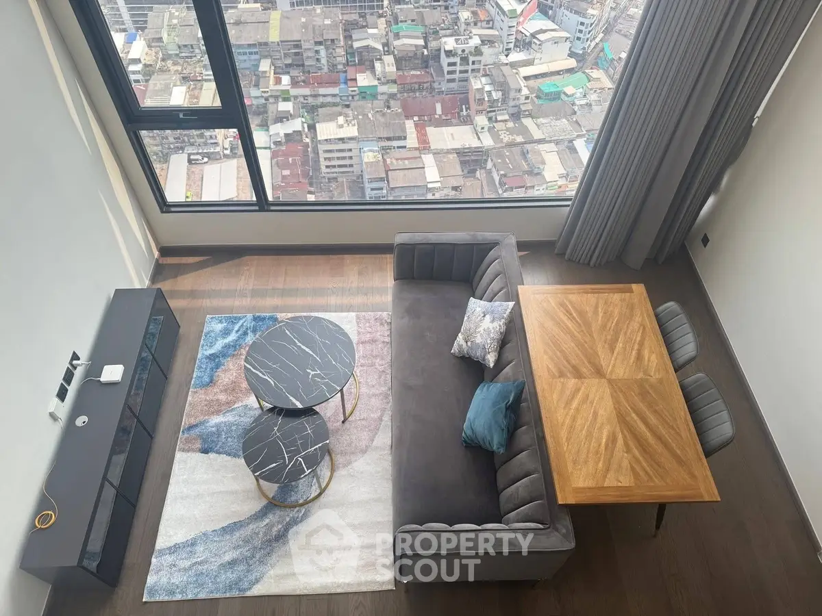 Modern living room with stunning city view from high-rise apartment window.
