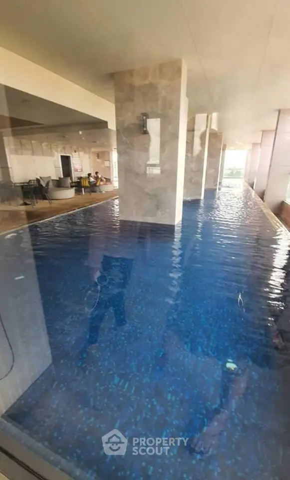 Luxurious indoor pool with modern design and seating area, perfect for relaxation and leisure.