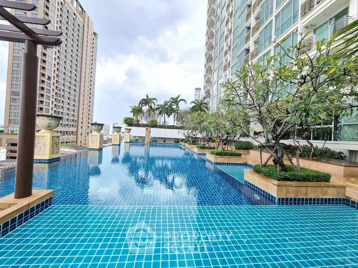 Luxurious high-rise building with stunning rooftop pool and lush greenery.
