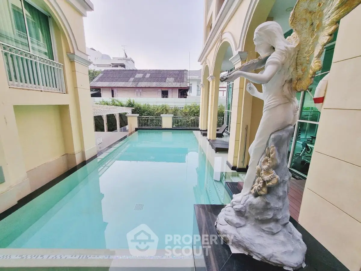 Luxurious pool area with elegant angel statue in upscale residential property