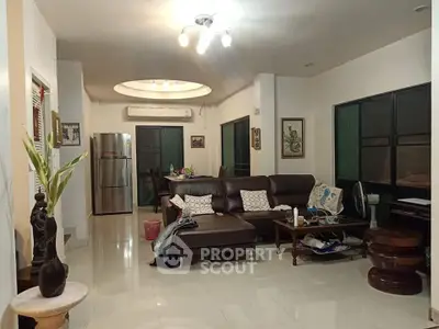 Spacious living room with modern decor and open layout, featuring a comfortable sofa and dining area.