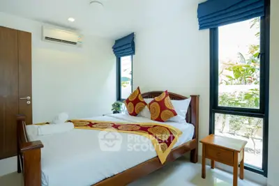 Bright and cozy bedroom with modern decor and large windows offering natural light.