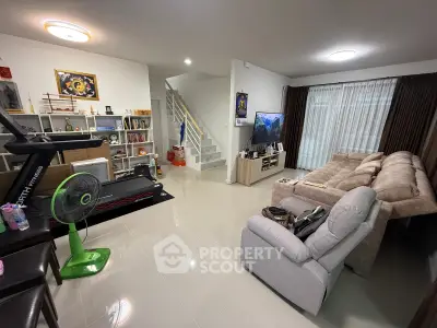 Spacious living room with modern decor, treadmill, and entertainment setup in a cozy home.