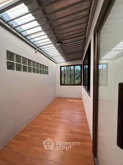 Spacious enclosed balcony with large windows and tiled flooring, perfect for relaxation and enjoying natural light.