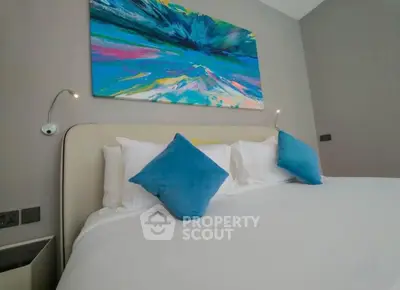 Modern bedroom with abstract art and plush pillows in a stylish apartment.