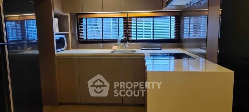 Modern kitchen with sleek cabinetry and large windows