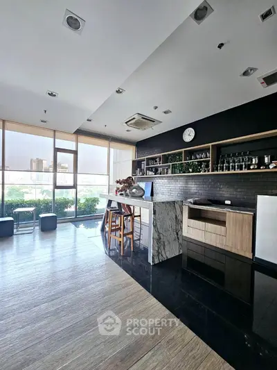 Modern kitchen with marble island and city view, featuring sleek cabinetry and ample natural light.