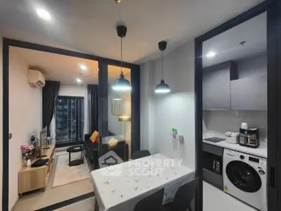 Modern apartment with open layout, featuring a cozy living room and functional kitchen with appliances.