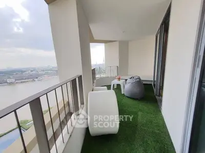 Spacious balcony with artificial grass and river view, perfect for relaxation.