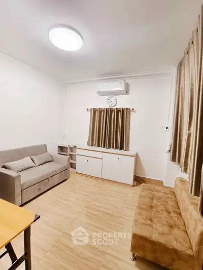 Cozy living room with modern furniture and air conditioning, perfect for relaxation.