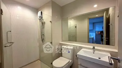 Modern bathroom with glass shower and sleek fixtures in a contemporary apartment.