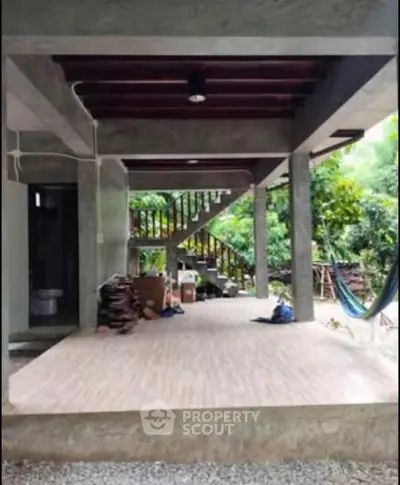 Spacious outdoor area with modern concrete design and lush greenery, perfect for relaxation and gatherings.