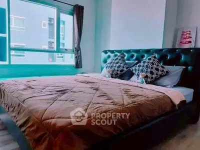 Cozy bedroom with stylish bed and large window offering natural light.