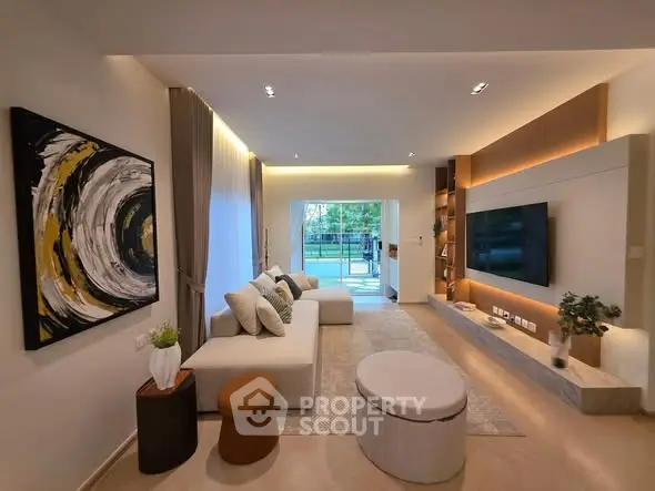 Modern living room with elegant decor and large TV, opening to a lush garden view.