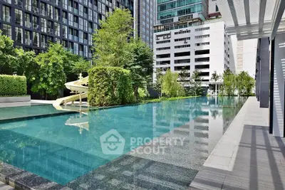 Luxurious urban apartment complex with stunning pool and lush greenery.
