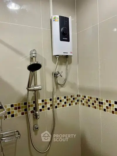 Modern bathroom with sleek shower and water heater, featuring stylish tile accents.
