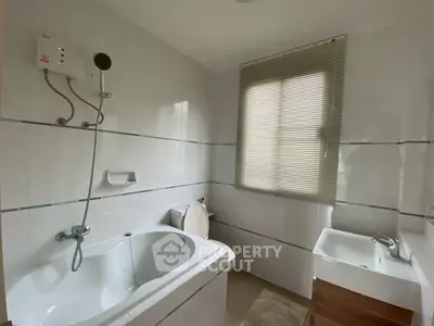 Modern bathroom with bathtub and sleek fixtures in a bright, minimalist design.