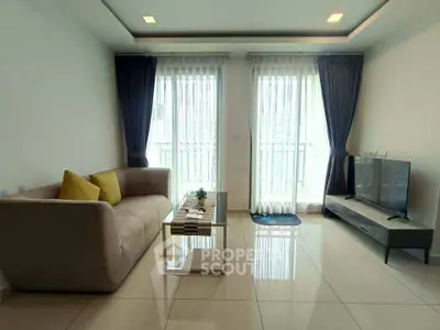 Modern living room with sleek furniture and large windows offering natural light.
