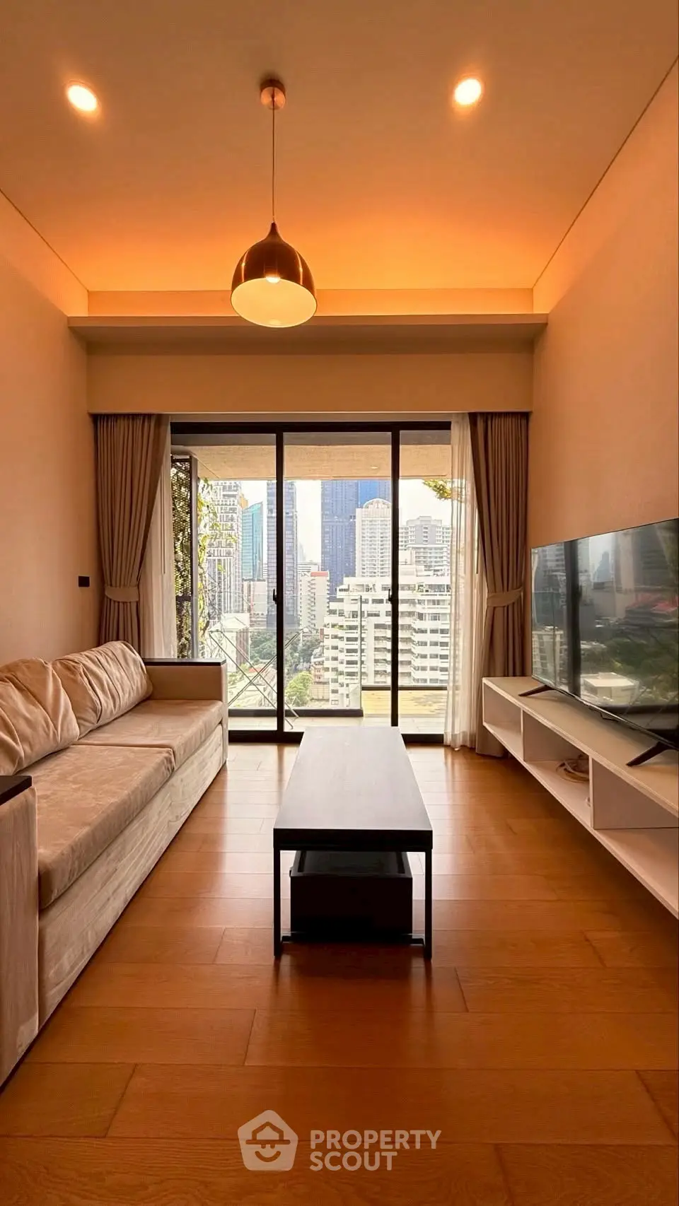 Modern living room with city view, featuring sleek furniture and large windows for natural light.