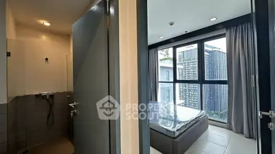 Modern apartment with bedroom and bathroom, featuring large windows and city view.