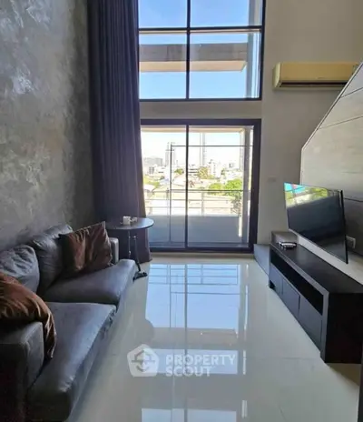 Modern living room with high ceiling and city view from large windows.
