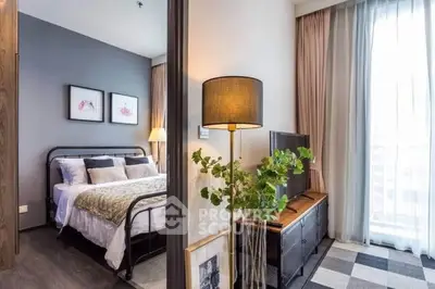 Modern bedroom with stylish decor and large window offering natural light