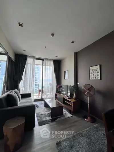 Modern living room with stylish decor and large windows offering city views.