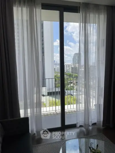 Modern apartment with floor-to-ceiling windows offering stunning city views and abundant natural light.
