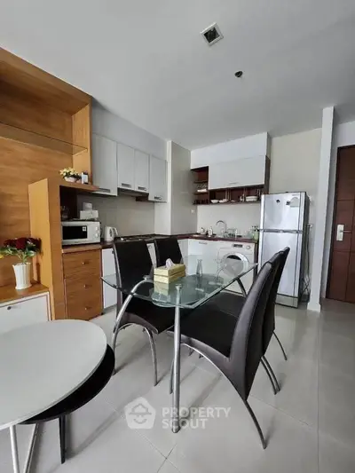 Modern kitchen with sleek appliances and dining area in a stylish apartment.