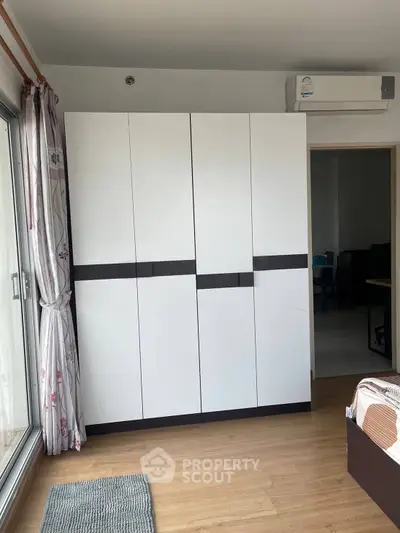 Modern bedroom with sleek wardrobe and air conditioning unit