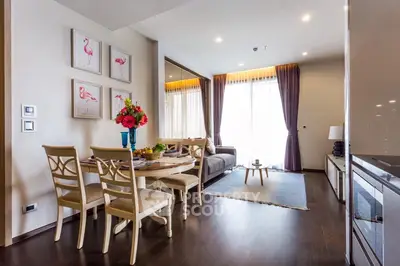 Elegant living room with dining area, modern decor, and natural light from large windows.