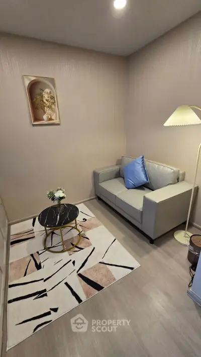 Cozy living room with modern decor, featuring a stylish sofa, chic coffee table, and elegant floor lamp.