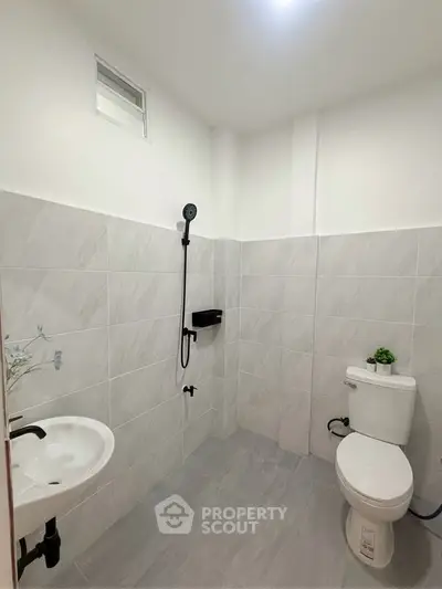 Modern minimalist bathroom with sleek fixtures and tiled walls, perfect for a contemporary home.