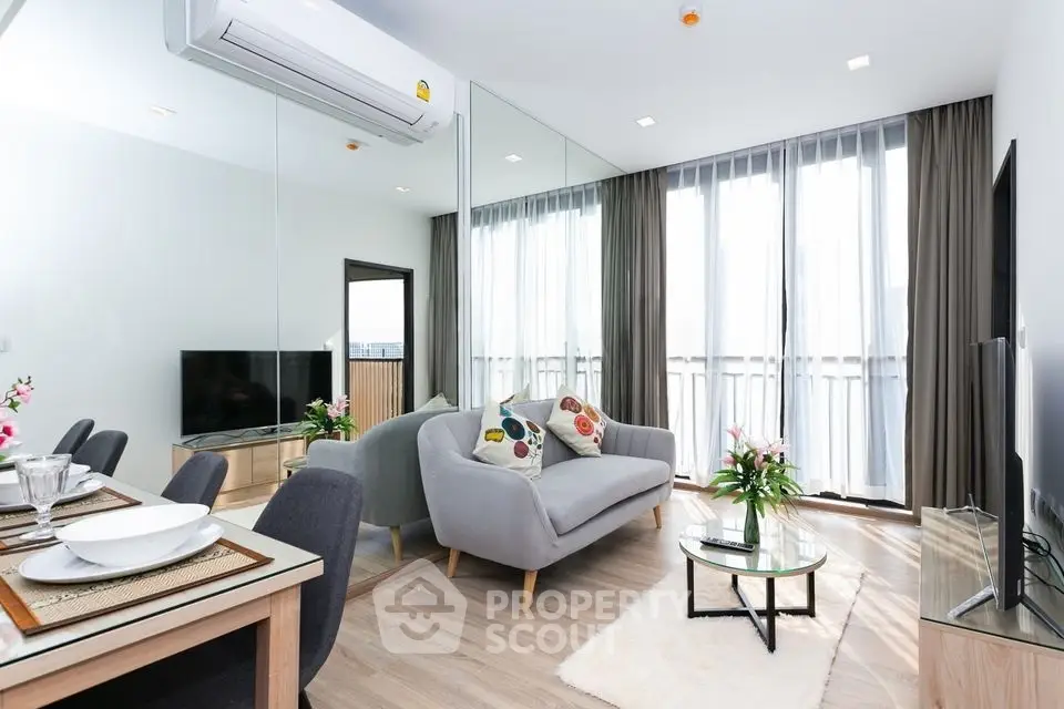 Modern living room with stylish decor, large windows, and cozy seating area in a contemporary apartment.