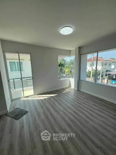 Bright and spacious empty room with large windows and modern flooring