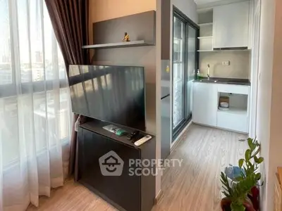 Modern living room with sleek TV stand and adjacent compact kitchen area.